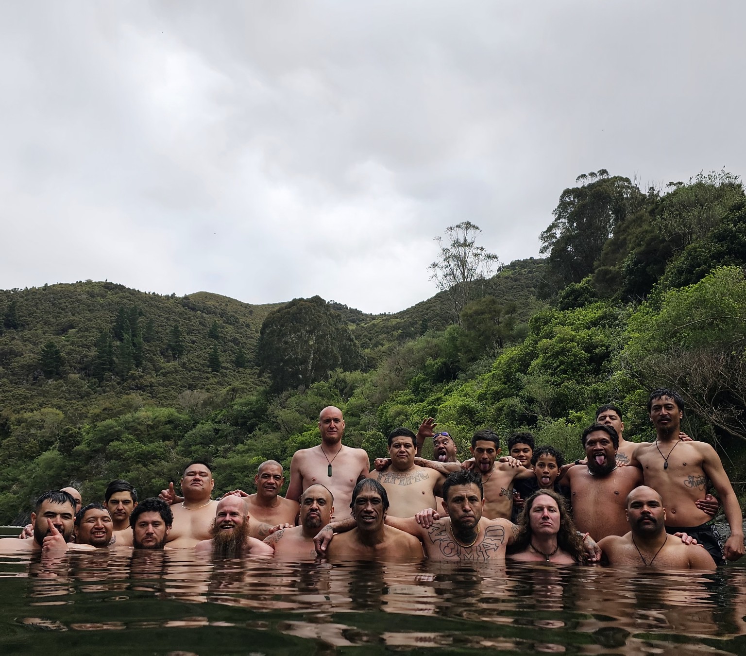 Tāne standing together in the wai during an Ahu Collective wānanga
